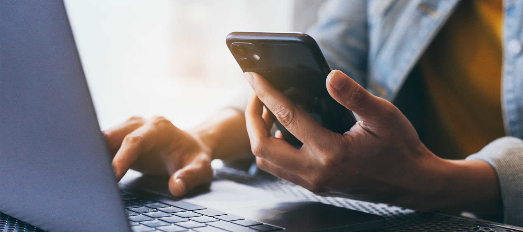 Woman using phone and laptop